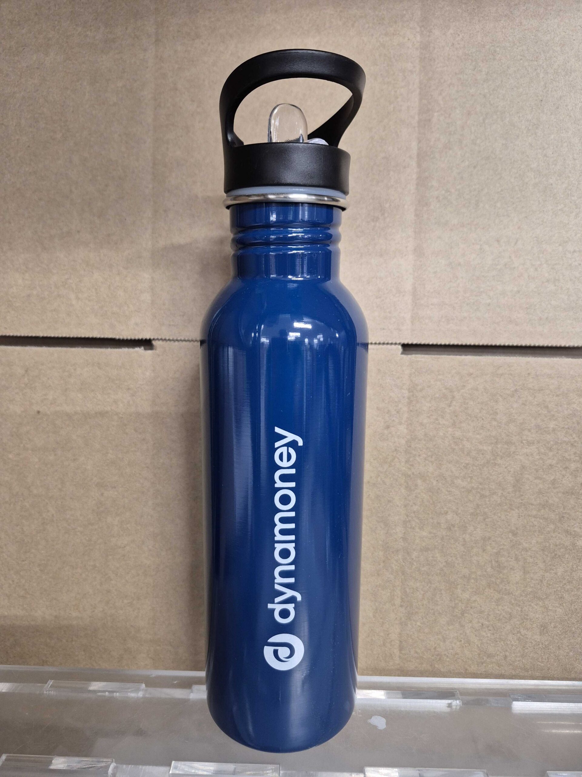 Blue water bottle with dynomoney logoβperfect event and tradeshow swag on a cardboard background.