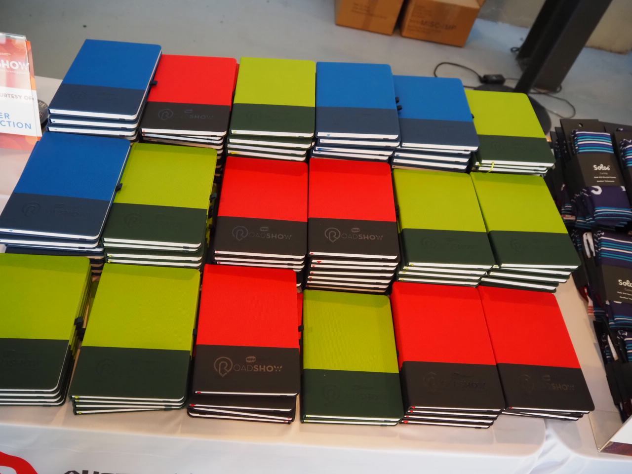 Stacked red, green, and blue notebooks arranged neatly—perfect for bulk order benefits.