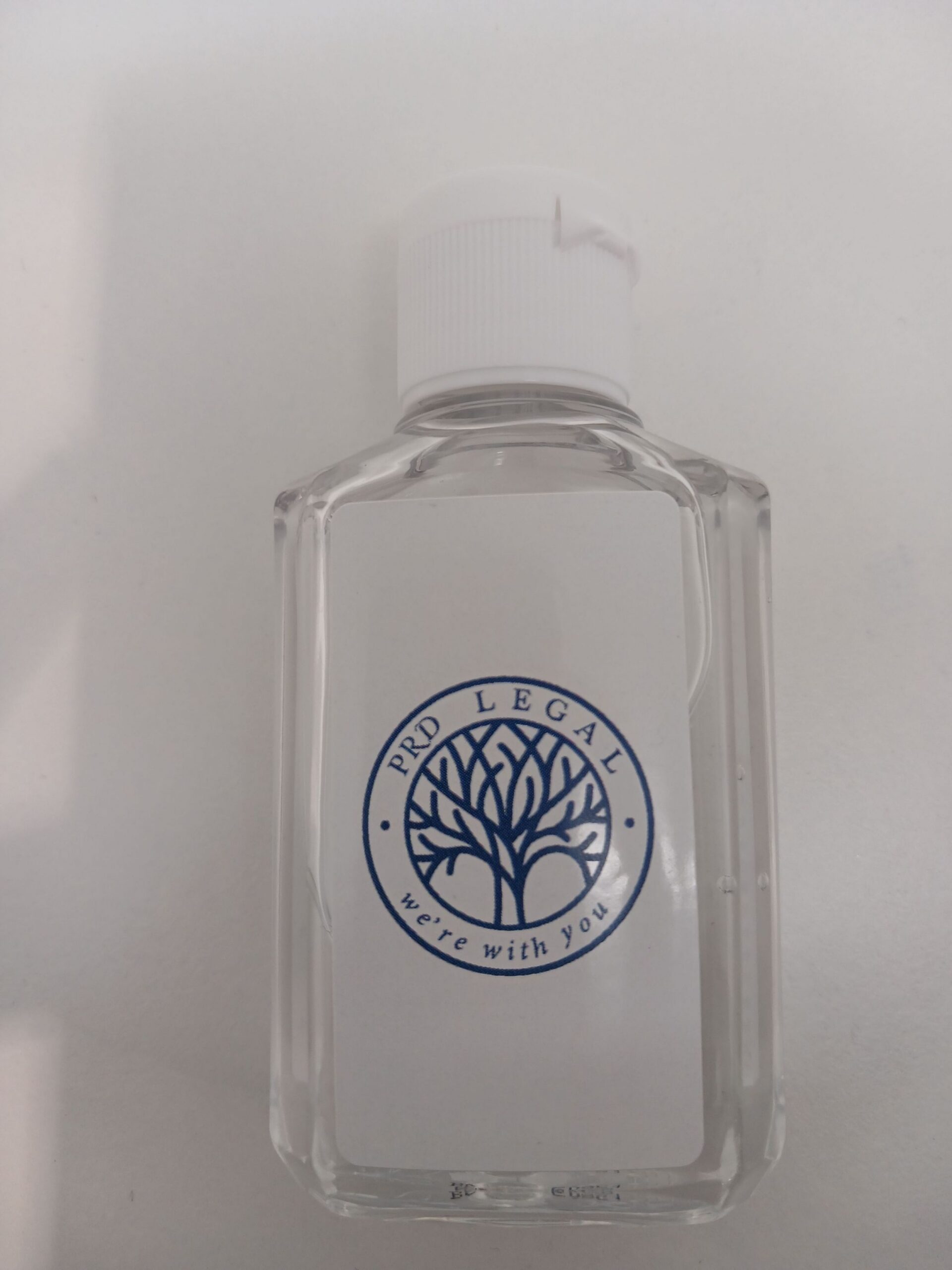 Clear bottle with white cap, PRD Legal label, blue tree logo—happy client approved.