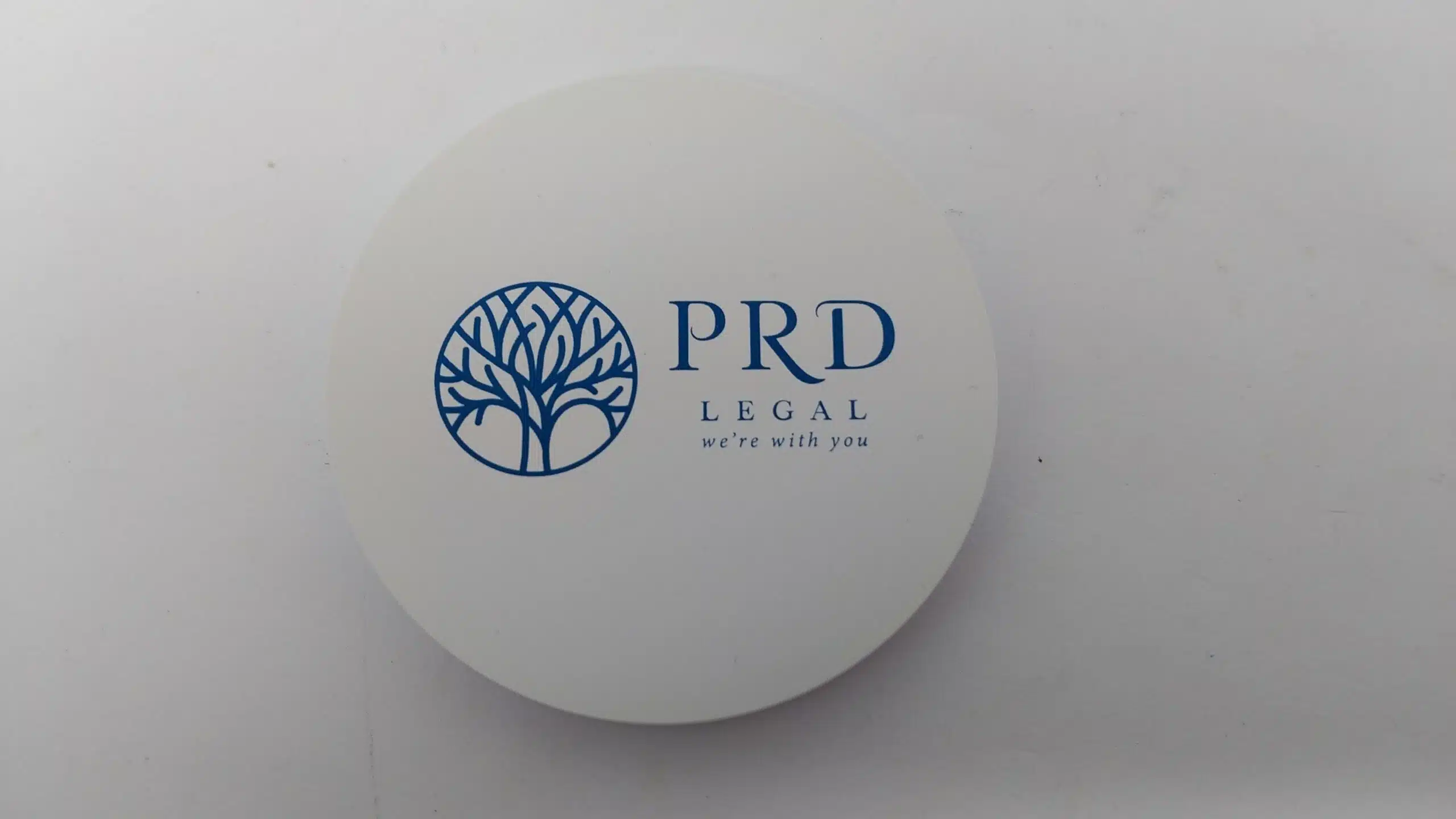 Round white item with blue PRD Legal logo and Happy Client text on a plain background.