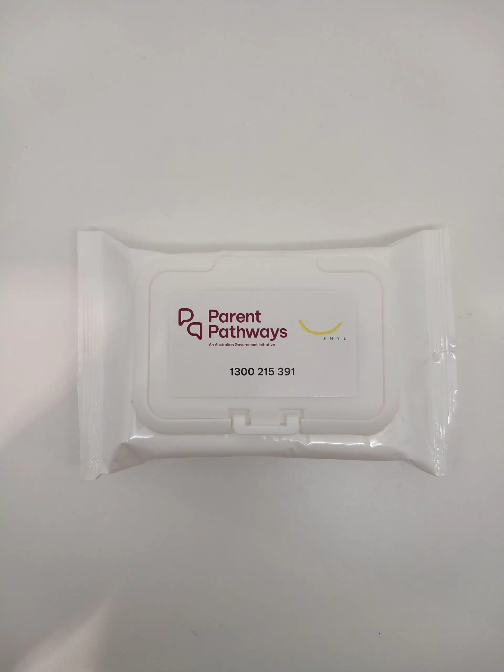 White packet of SMYL wipes labeled Parent Pathways with a phone number on a white surface.