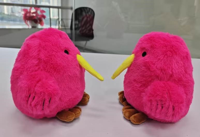 two pink kiwi plushies facing each other