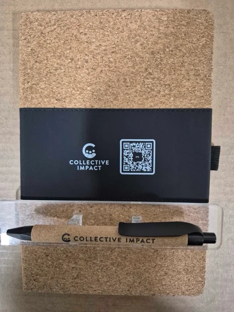 notebook and pen branded with Collective Impact logo