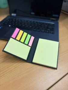 Opened sticky note pad set showing a yellow sticky pad and five colour page flag strips.