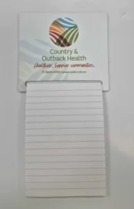 Magnetic notepad with Country & Outback Health logo and tagline printed on the header card, with lined pages below.