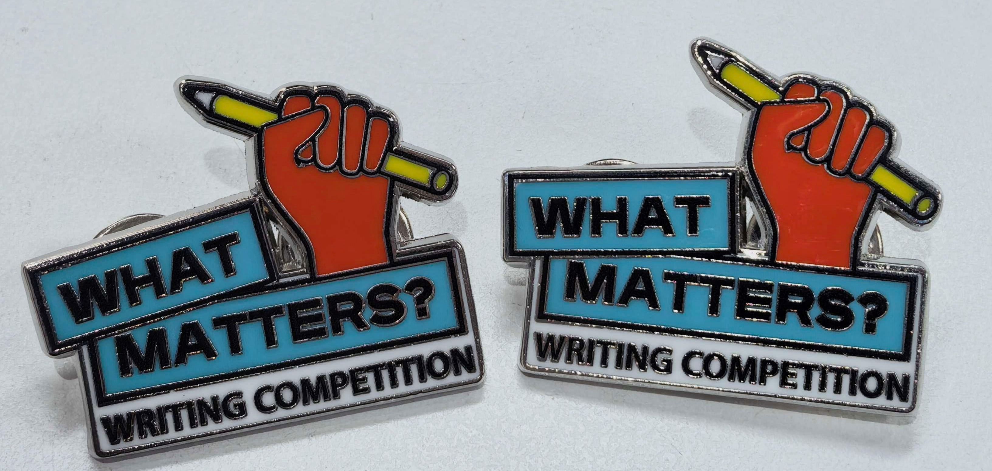 two pins customised with hand, pencil and what matters text