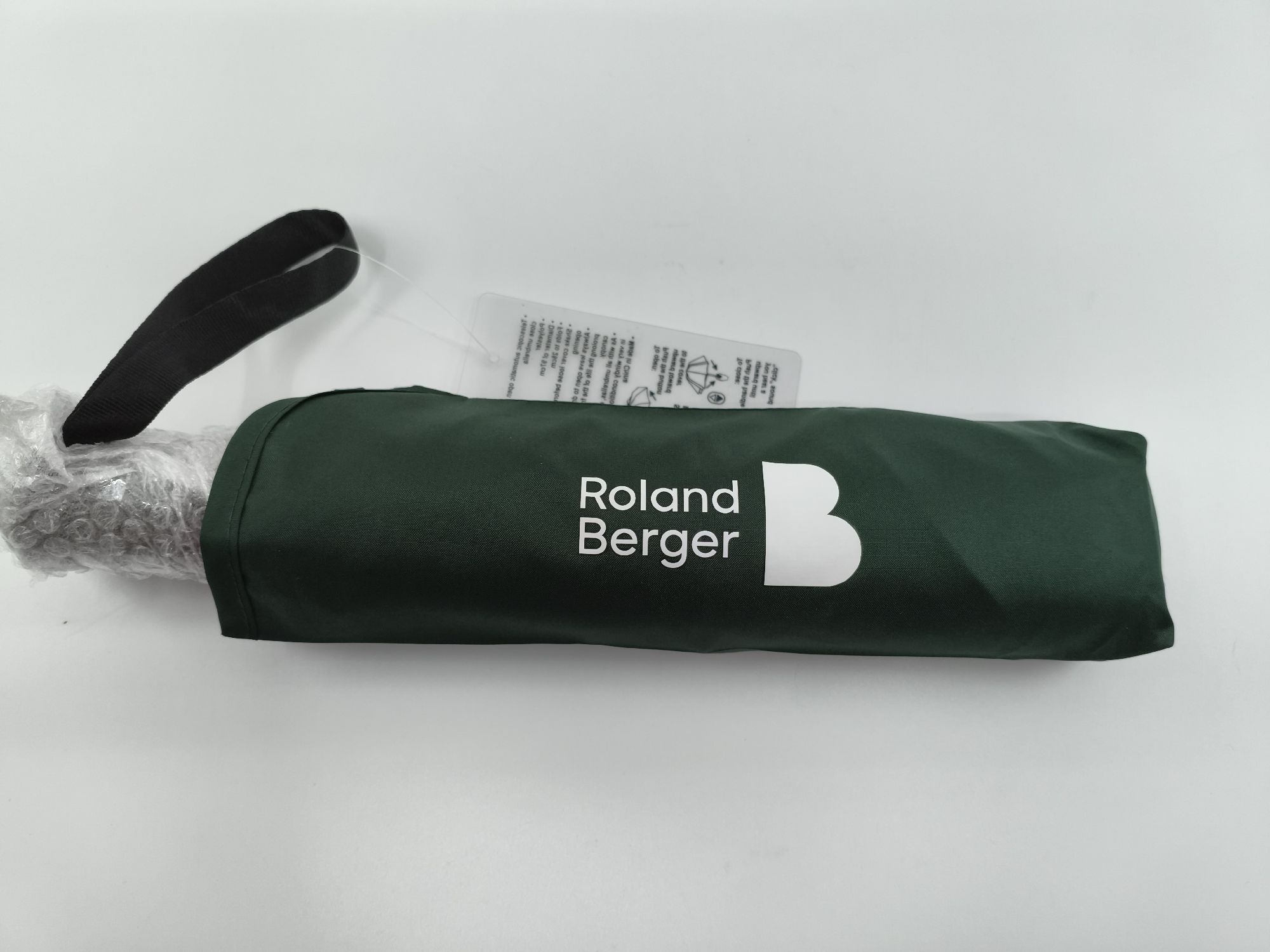 green folded umbrella giveaway printed with Roland Berger logo