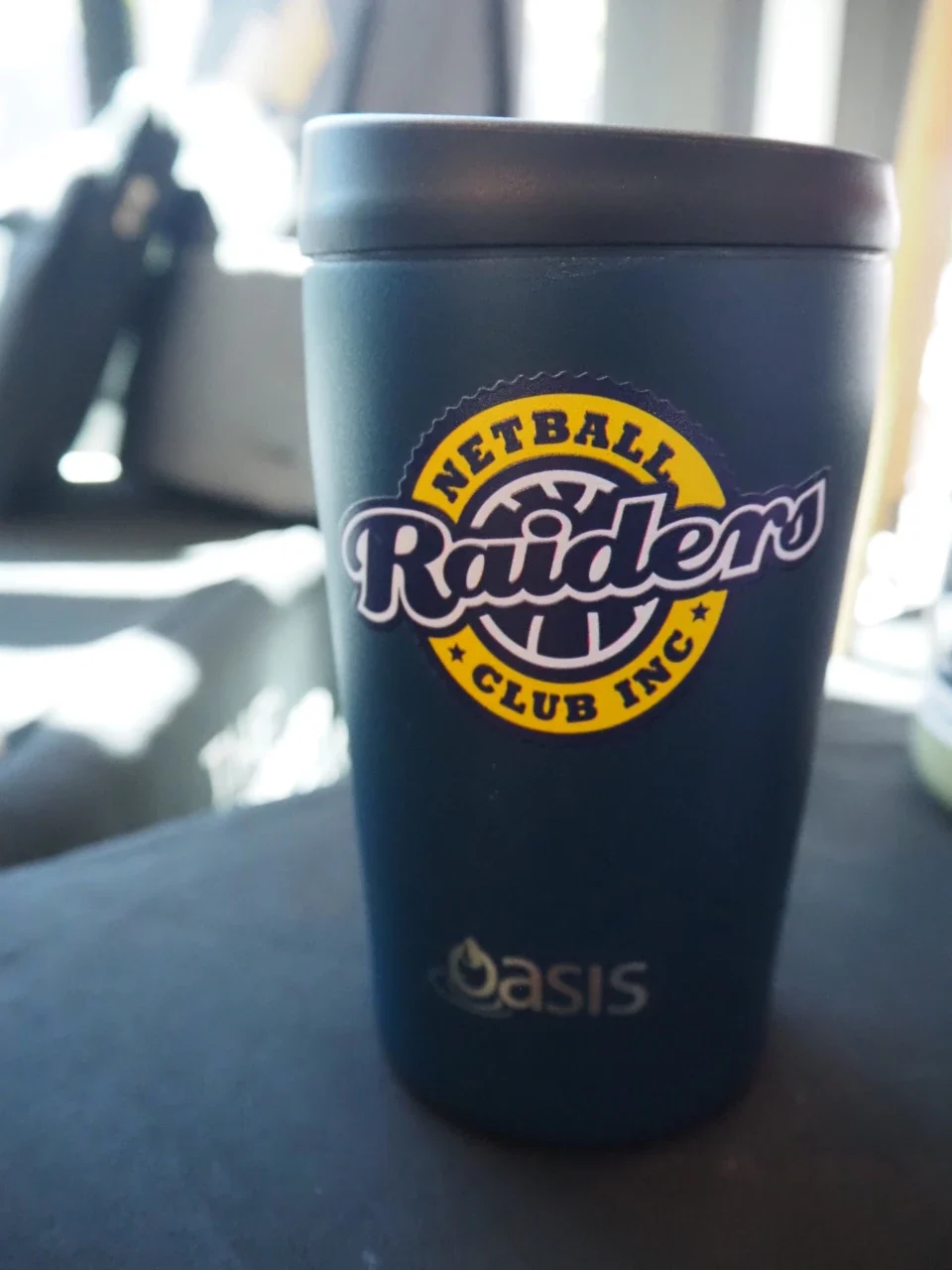 insulated travel mug with netball raiders logo