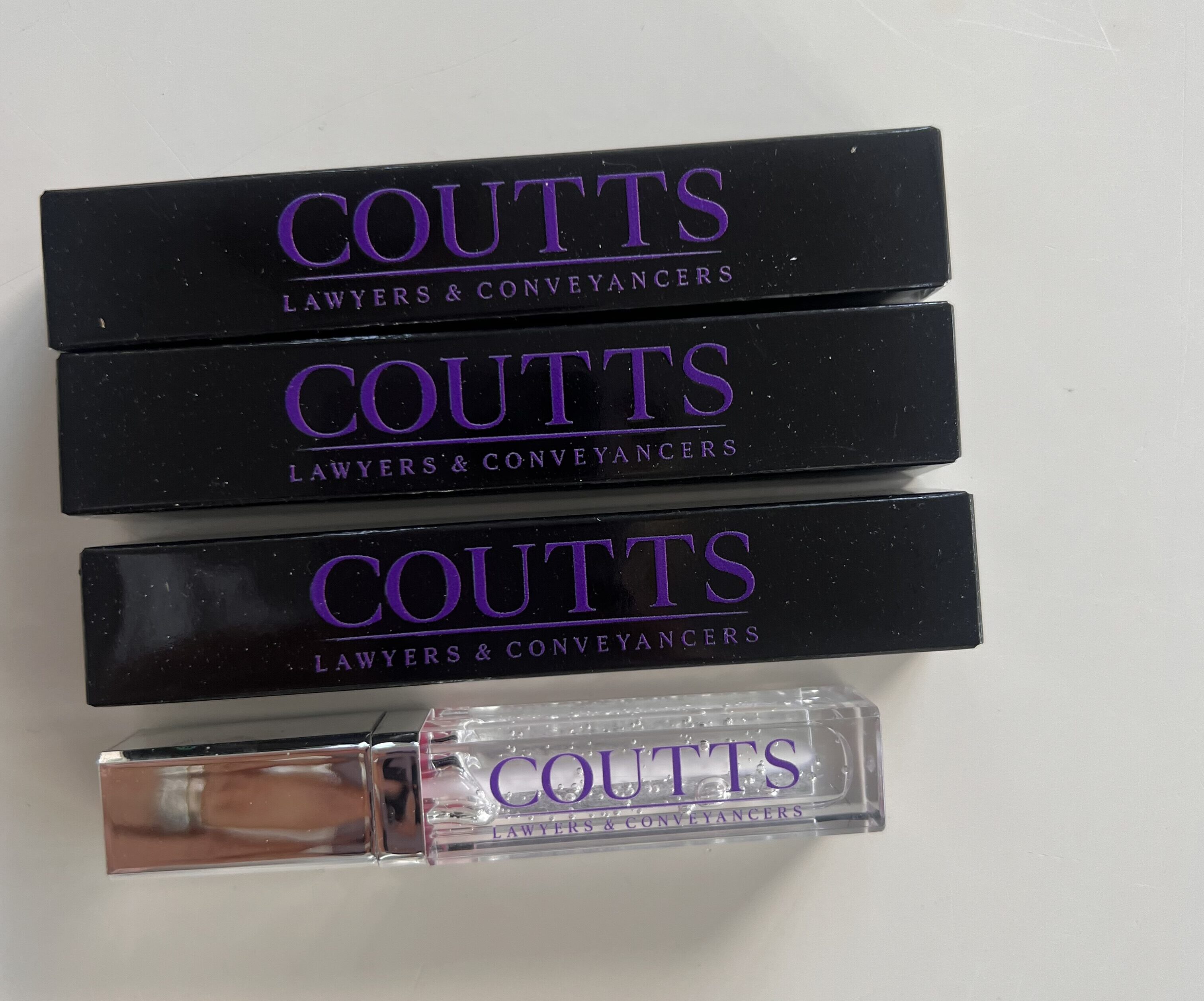 lip glosses in black boxes branded with logo