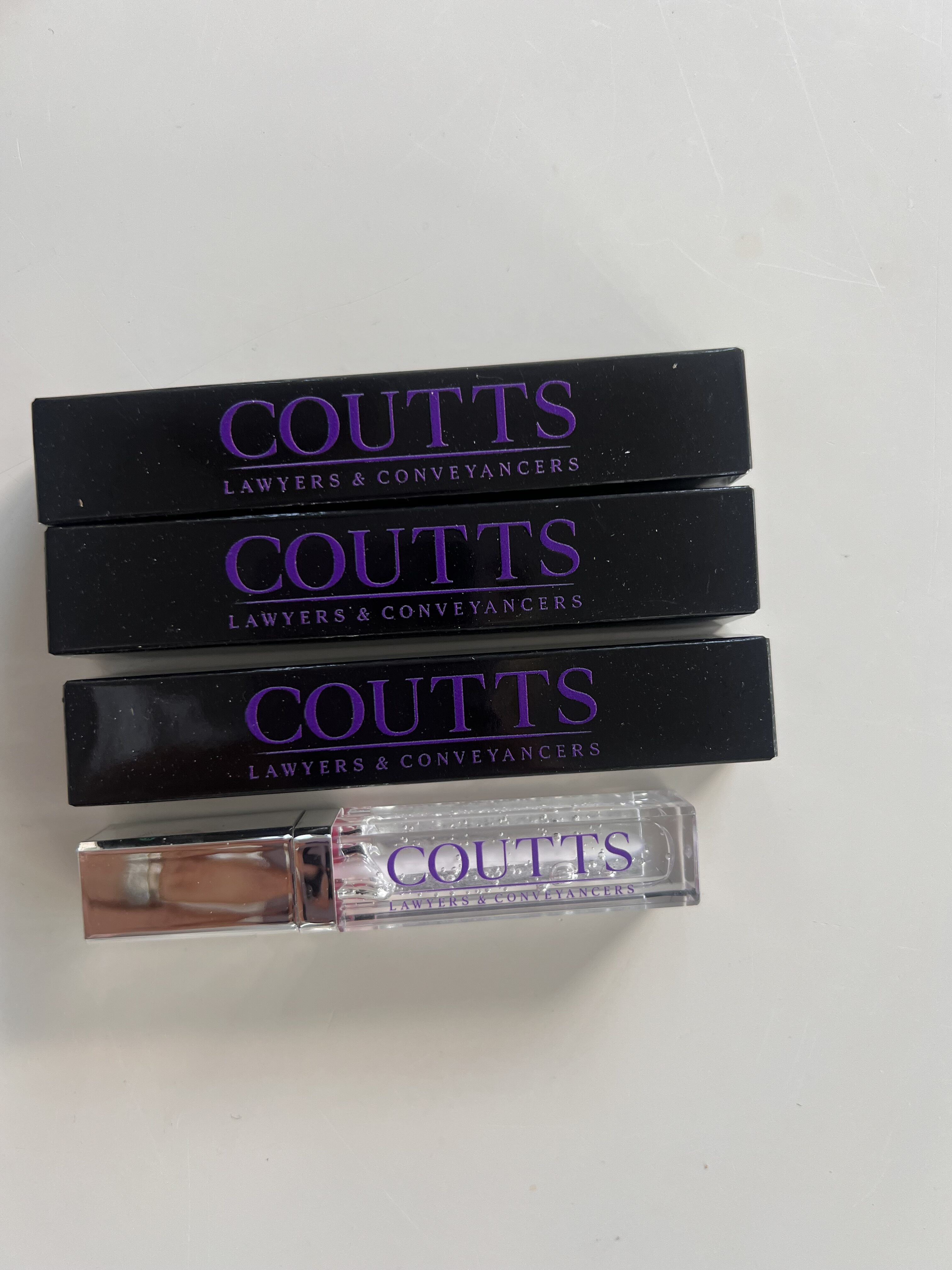 lip glosses in black boxes branded with logo