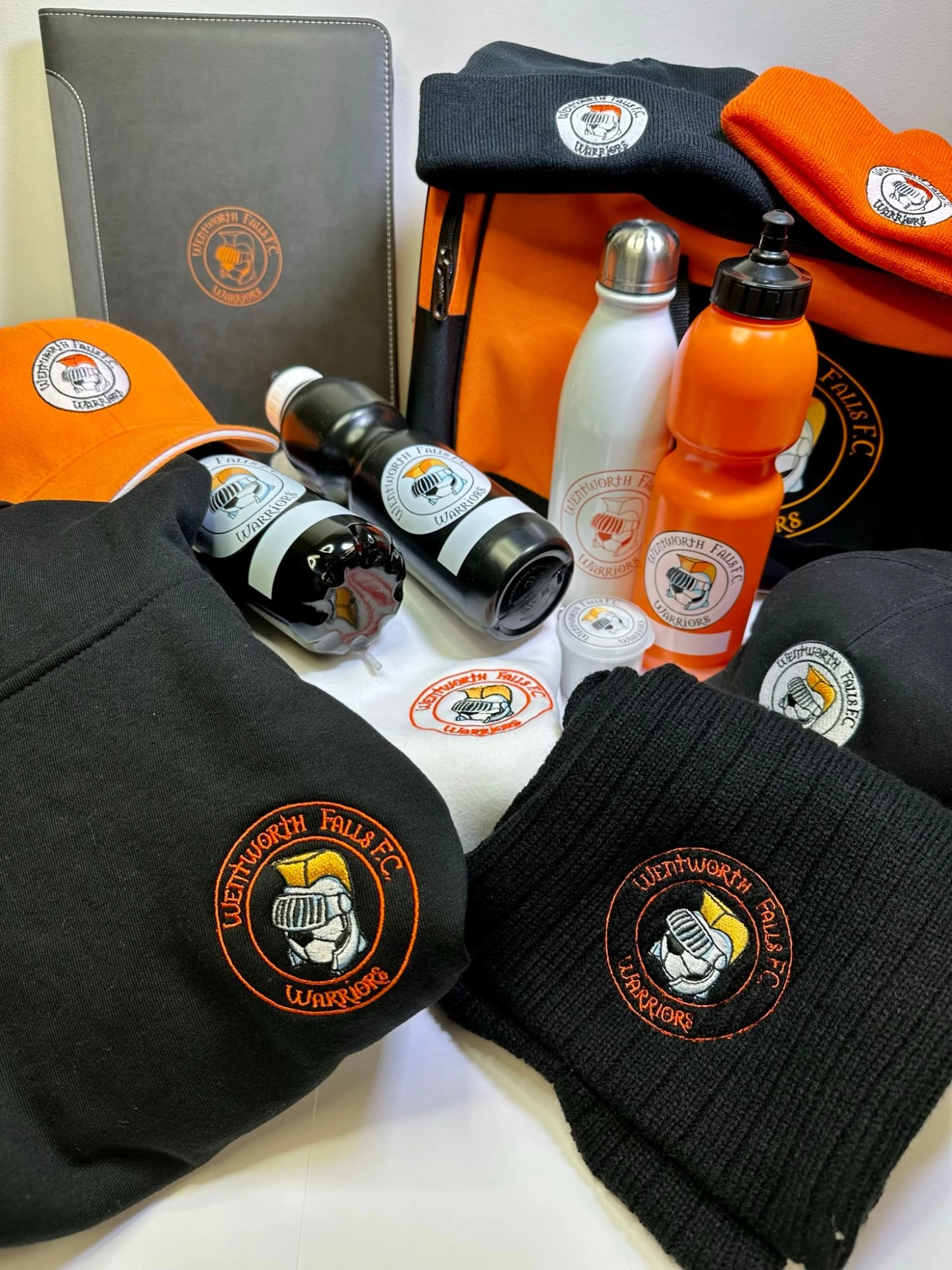 Wentworth Falls FC branded club merchandise including embroidered hoodie, scarf, beanies, caps, drink bottles and sports bag