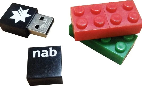 USB drive and toy building blocks, one labeled nab, on a white background.