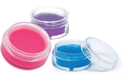 Three small round containers with pink, blue, and purple cream or gel inside.