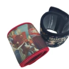 The Stubby Cooler Wrap features two fabric wristbands with vibrant designs: one showcases a Coca-Cola theme with a marching band, while the other boasts Hopkins Live. Both wristbands are rolled up to reveal their colorful patterns and red lining.