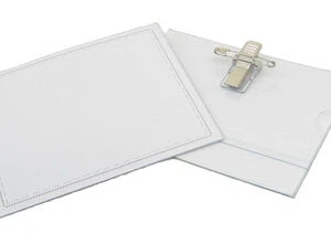 Two blank white name badges with clips attached, lying on a white surface.