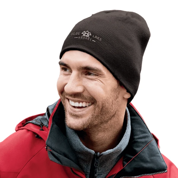 Smiling man in a black beanie and red jacket looking to the side.