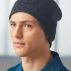 Person wearing a dark beanie and blue shirt, looking to the side.