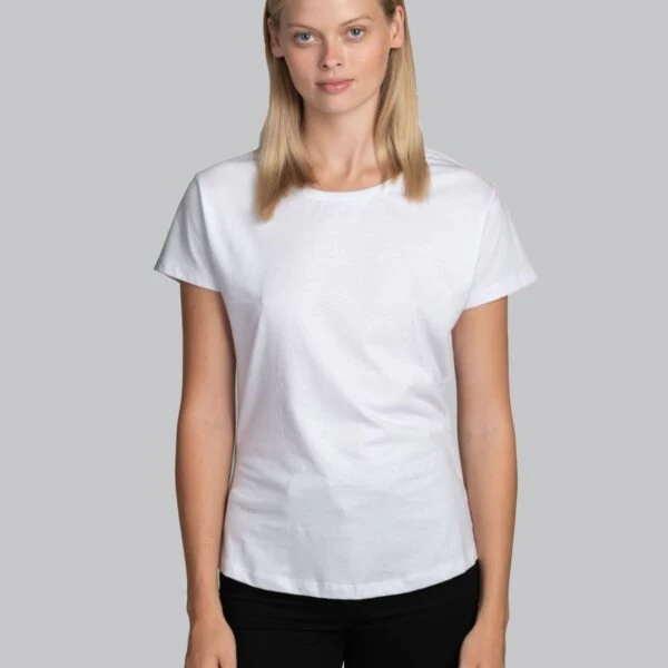Woman in a plain white t-shirt and black pants standing against a gray background.