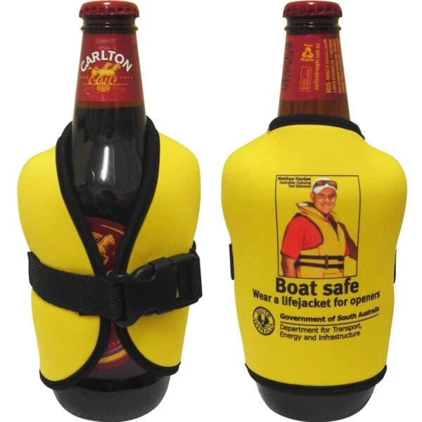 Two beer bottles in yellow life jacket koozies. The front bottle features a Carlton label, while the back bottle displays a safety message with an image of a man in a life jacket, promoting safe boating practices.
