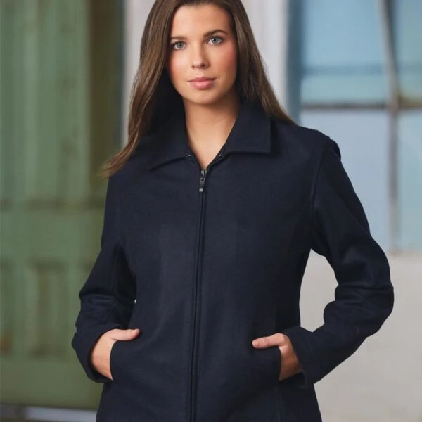 Person in a dark jacket stands with hands in pockets, looking forward.