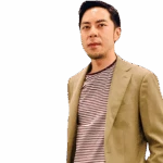 Charles Liu Man wearing a tan blazer over a striped shirt