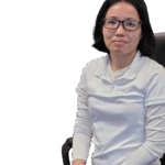 Woman with glasses in a white shirt seated on a chair