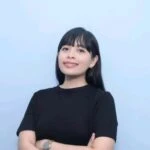 Woman in black shirt smiles with arms crossed