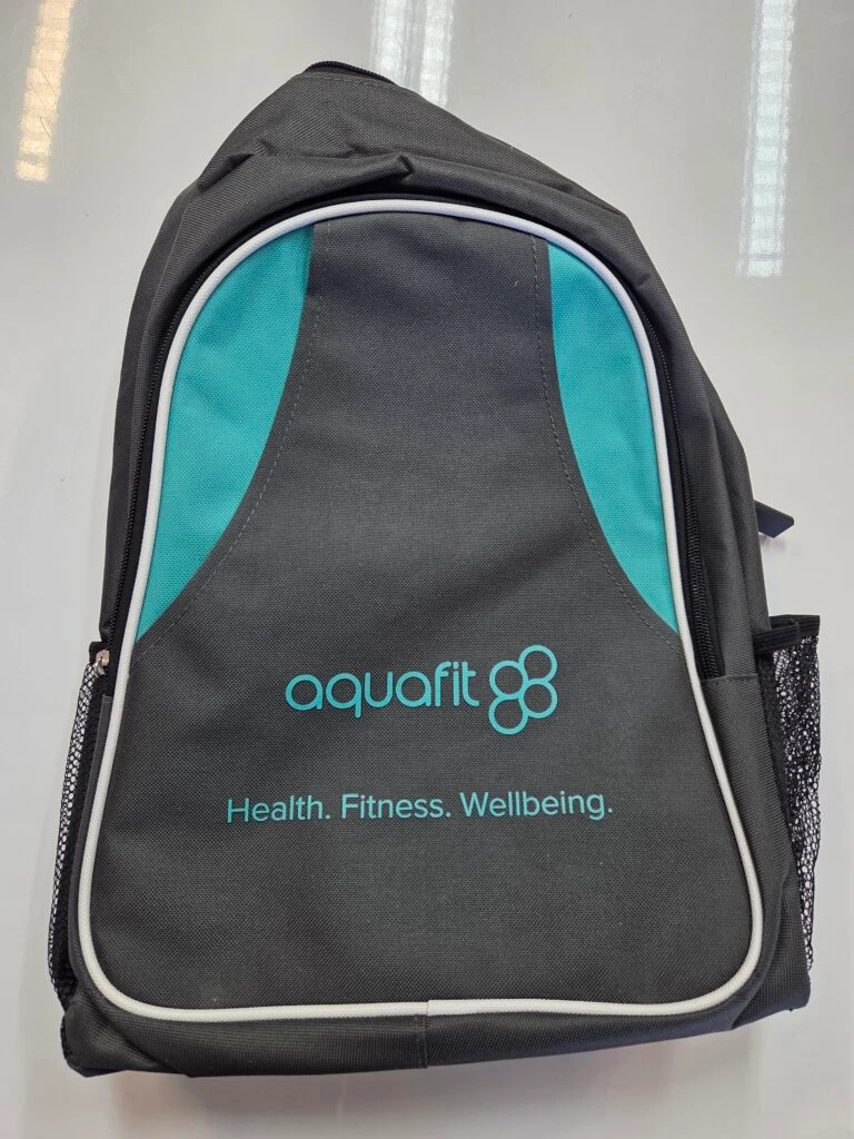 A gray and teal Aquafit backpack bag with Health. Fitness. Wellbeing. printed on the front.